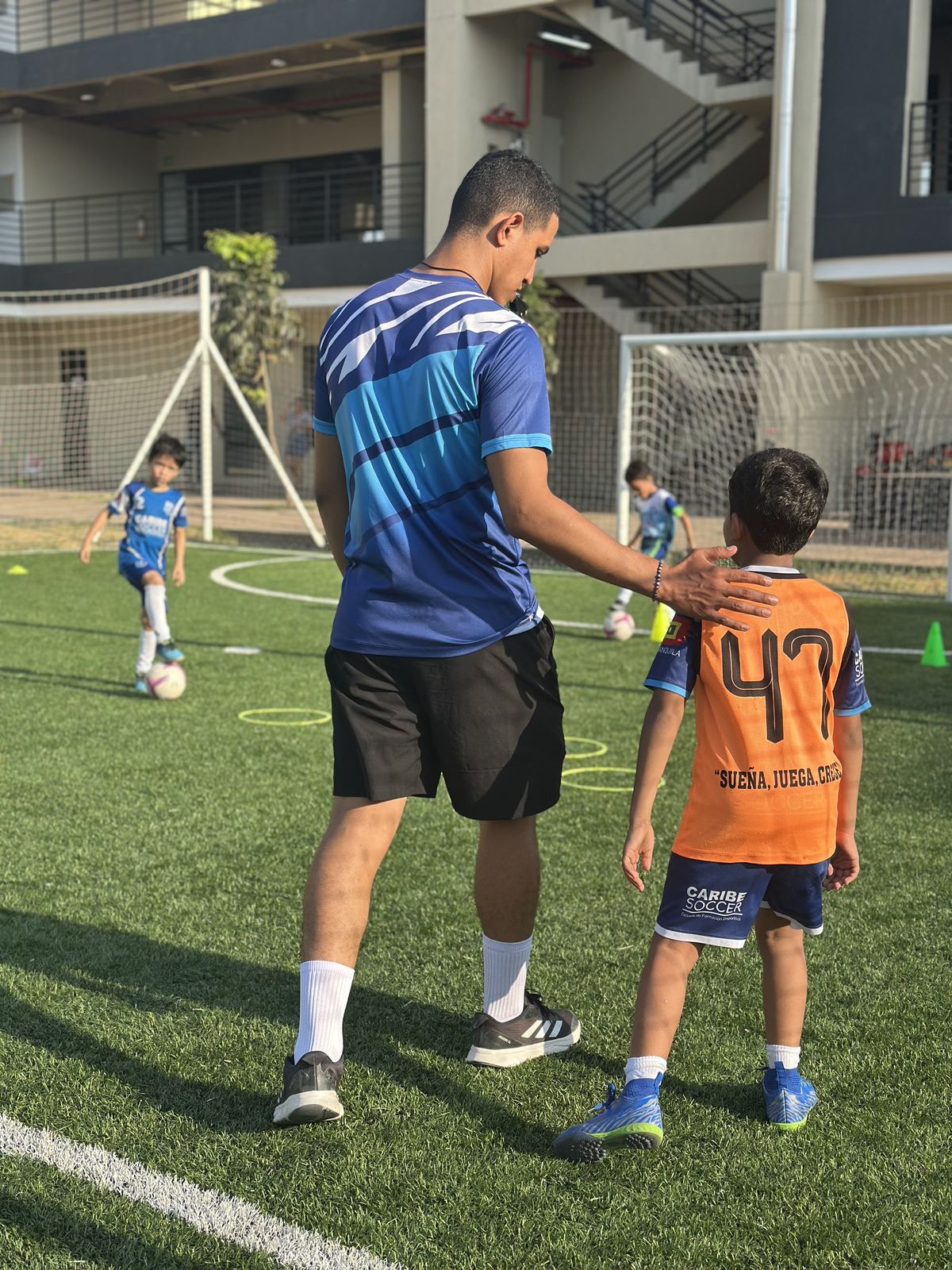Entrenador acompañando a un niño en la cancha
