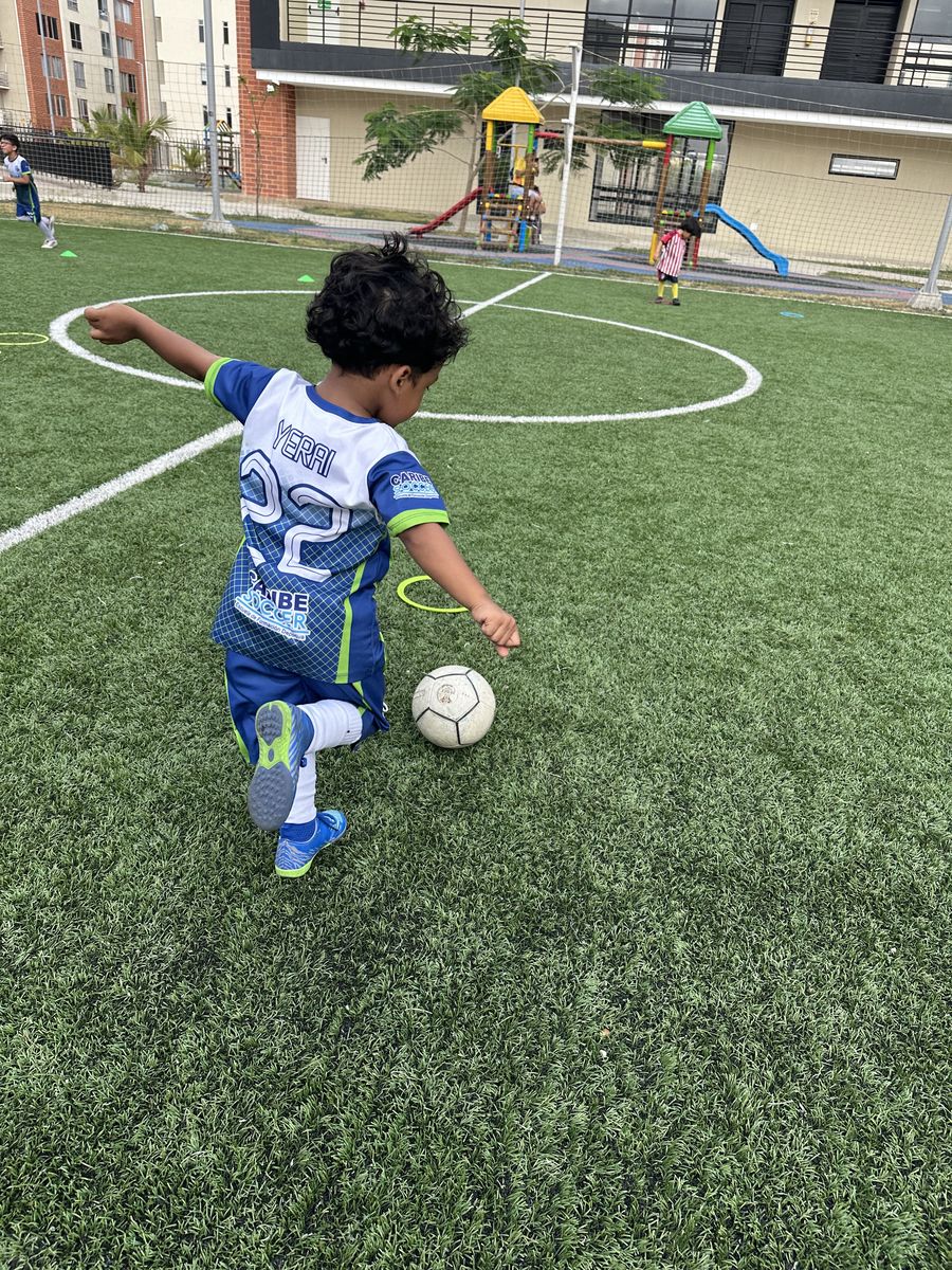 Niño caminando hacia la cancha con el balón