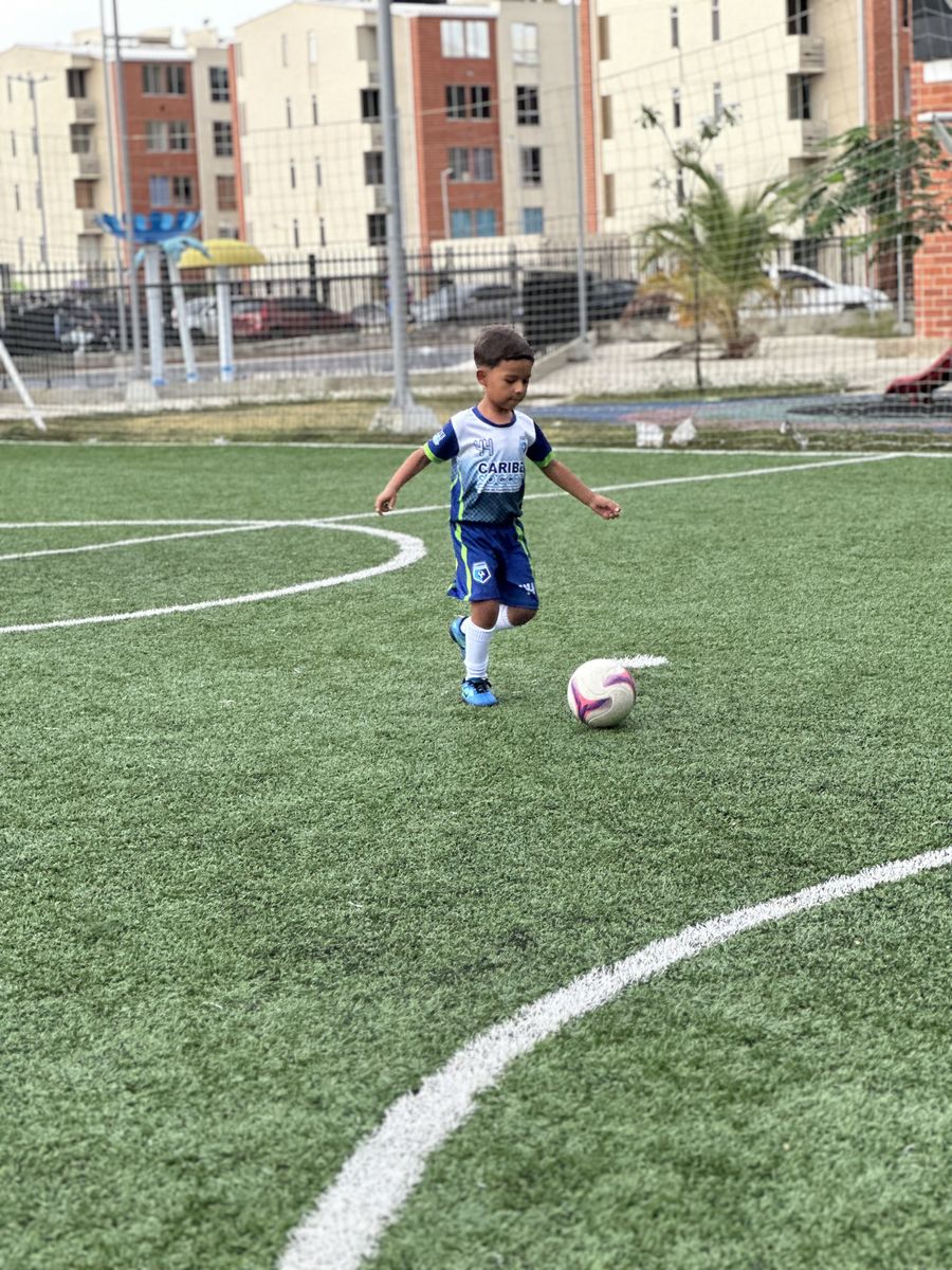 Niño conduciendo el balón