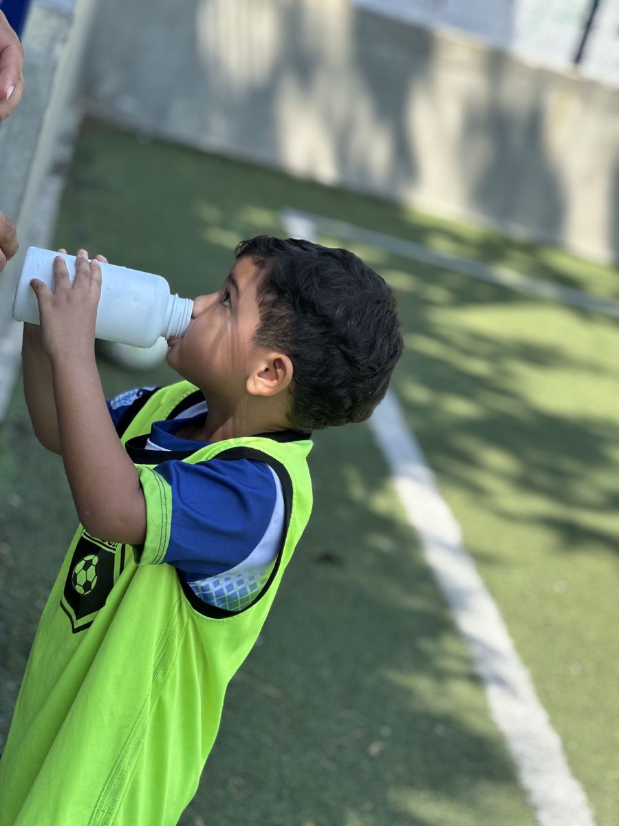 Niño hidratándose en el entrenamiento